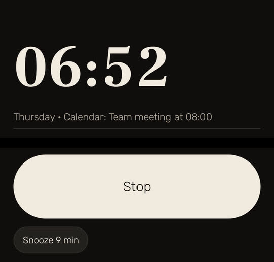 Wakira screen: the alarm ringing at 06:52, with "Thursday • Calendar: Team meeting at 08:00" under the time and the buttons Stop and "Snooze 9 min". The empty middle of the screen is left out.