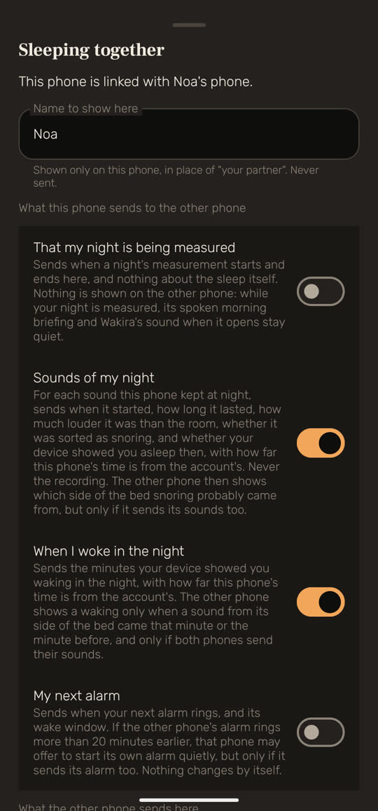 Wakira screen, with example data: "Sleeping together", with "This phone is linked with Noa's phone." and a name field showing "Noa". Below, "What this phone sends to the other phone" and four switches, each with an explanation: "That my night is being measured" is off, "Sounds of my night" is on, "When I woke in the night" is on, and "My next alarm" is off.