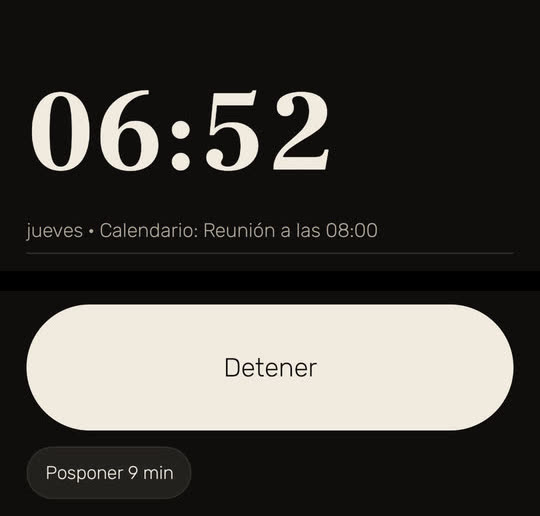 Pantalla de Wakira, con datos de ejemplo: la alarma sonando a las 06:52, con «jueves • Calendario: Reunión a las 08:00» bajo la hora, y los botones «Detener» y «Posponer 9 min».