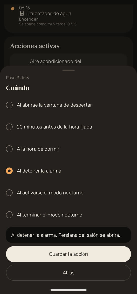 Pantalla de Wakira, con datos de ejemplo: una acción nueva, paso 3 de 3, «Cuándo», con «Al detener la alarma» elegido y la frase «Al detener la alarma, Persiana del salón se abrirá.»