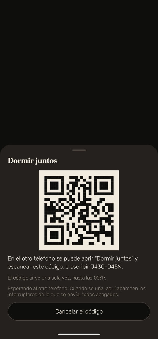 Pantalla de Wakira, con datos de ejemplo: «Dormir juntos», con un código QR y una línea que dice que en el otro teléfono se abre «Dormir juntos» y se escanea el código, o se escribe el código corto. Debajo: «El código sirve una sola vez, hasta las 00:17.» y «Esperando al otro teléfono. Cuando se una, aquí aparecen los interruptores de lo que se envía, todos apagados.» Abajo, el botón «Cancelar el código».