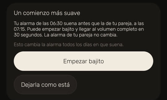 Pantalla de Wakira, con datos de ejemplo: «Un comienzo más suave». «Tu alarma de las 06:30 suena antes que la de tu pareja, a las 07:15. Puede empezar bajito y llegar al volumen completo en 30 segundos. La alarma de tu pareja no cambia.» Debajo: «Esto cambia la alarma todos los días en que suena.» Con los botones «Empezar bajito» y «Dejarla como está».